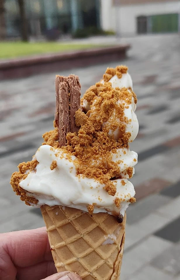 Ice cream cone topped with a biscuit