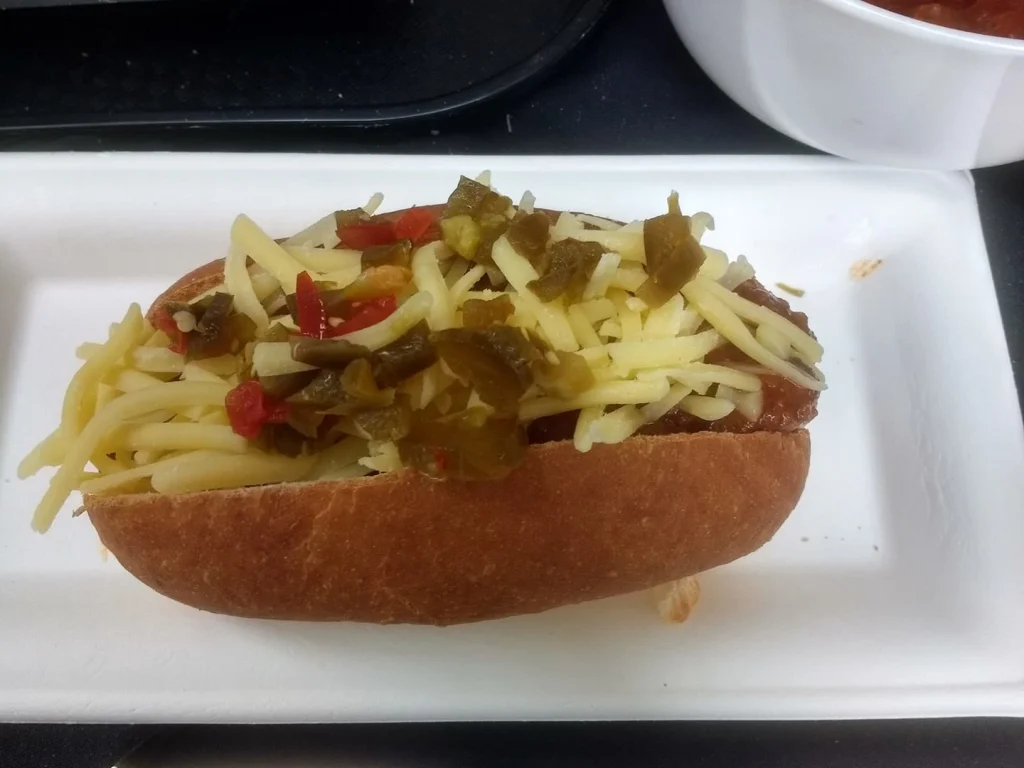 Loaded hot dog topped with cheese and jalapenos