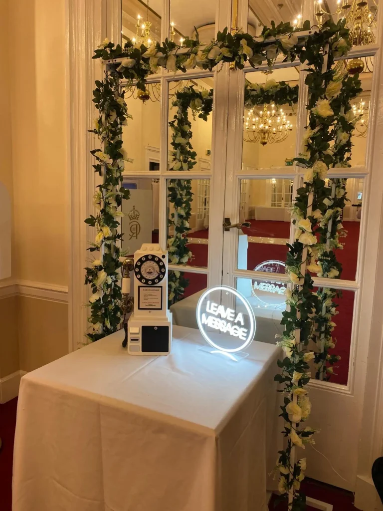 Photo booth framed with a greenery arch