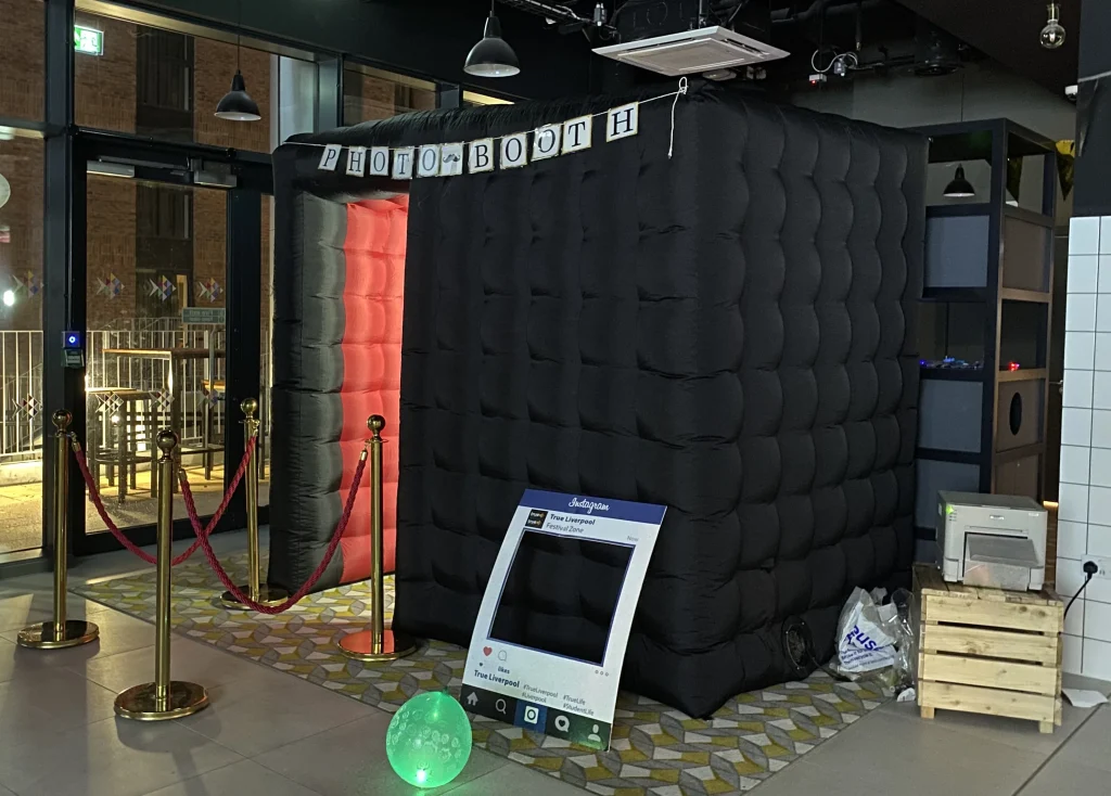 Black inflatable photo booth at an event