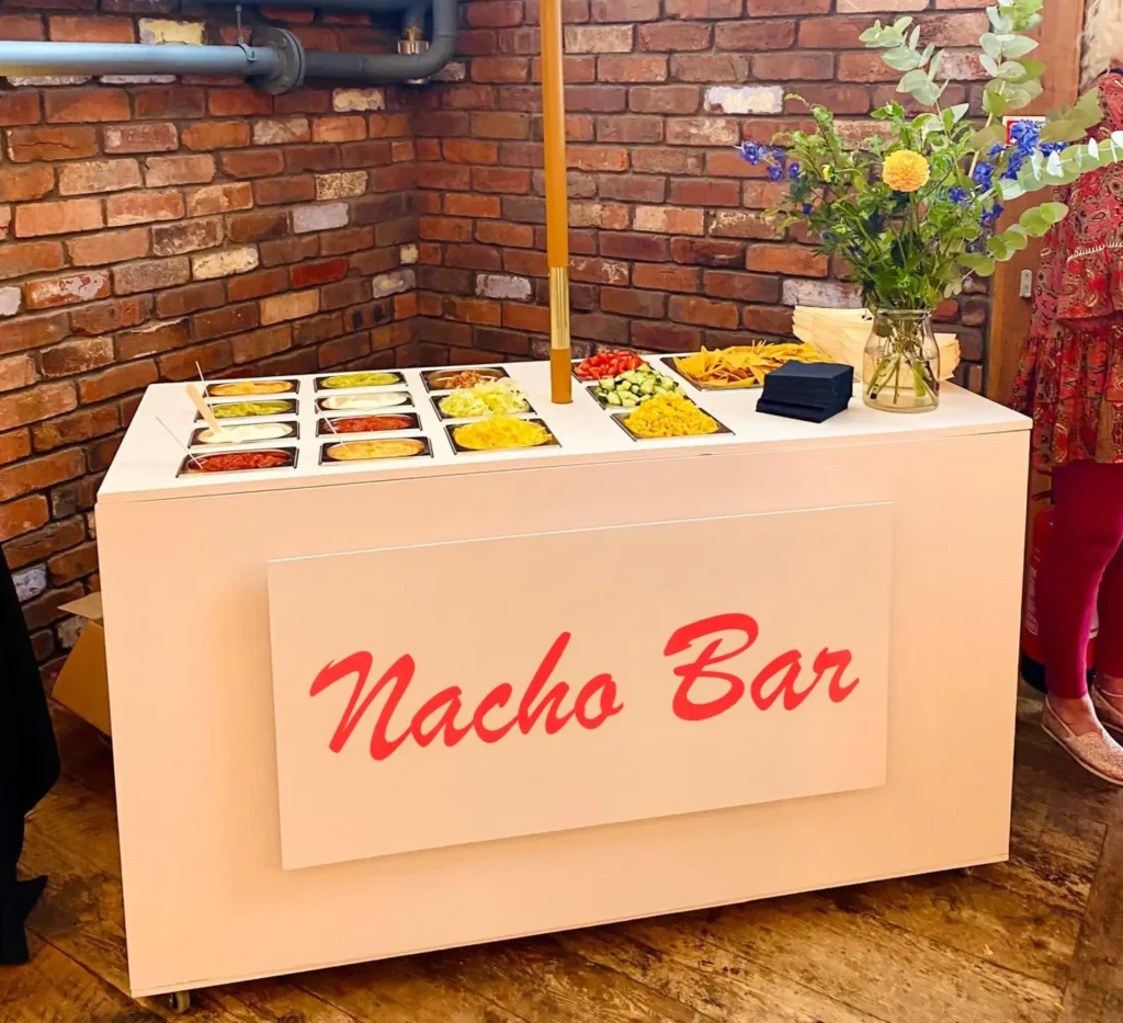 Nacho bar cart with toppings and a flower arrangement