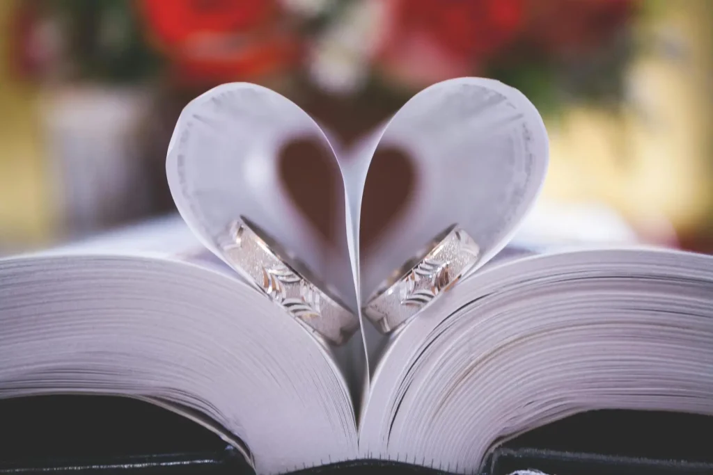Wedding rings on book pages folded into a heart