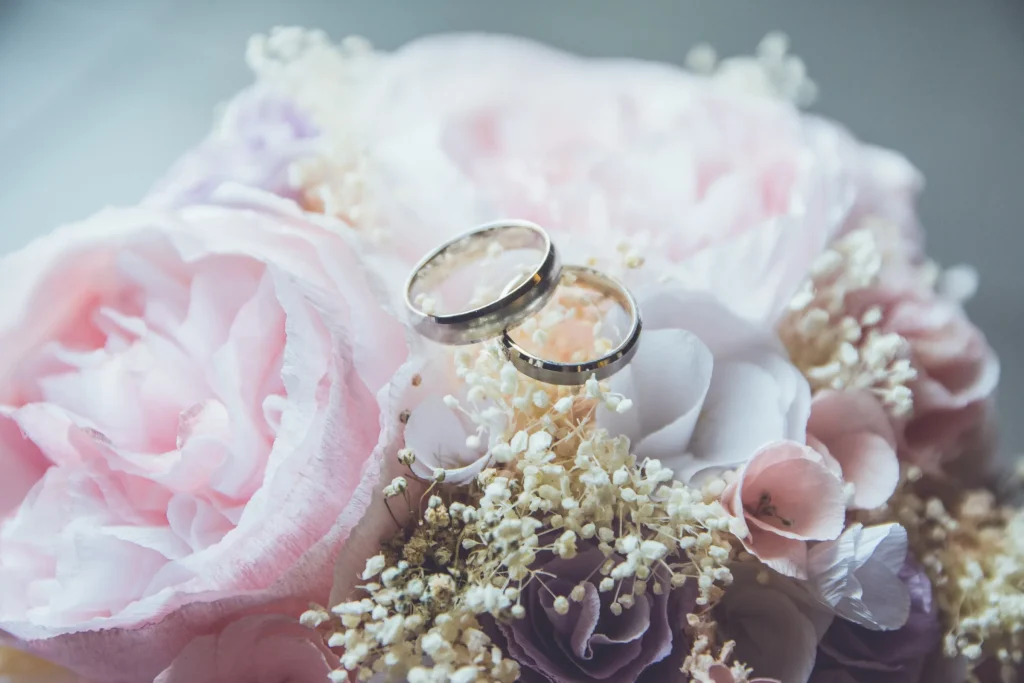 Wedding rings resting on pink roses