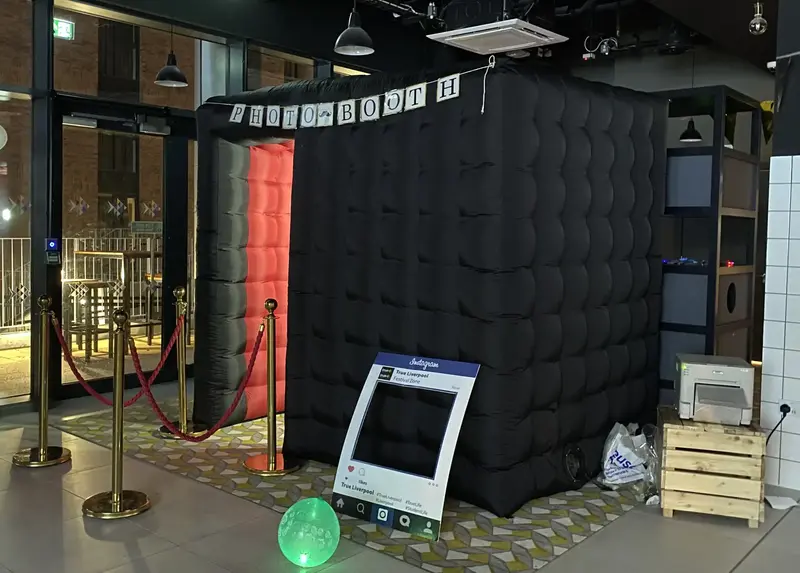 Black inflatable photo booth at an event