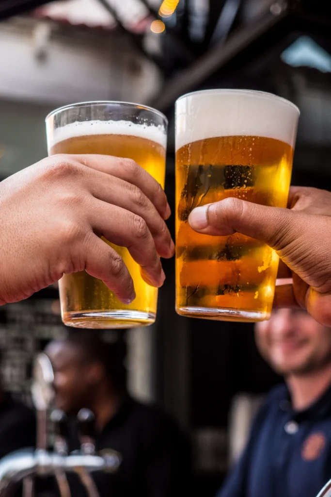 Two pints of beer being clinked together