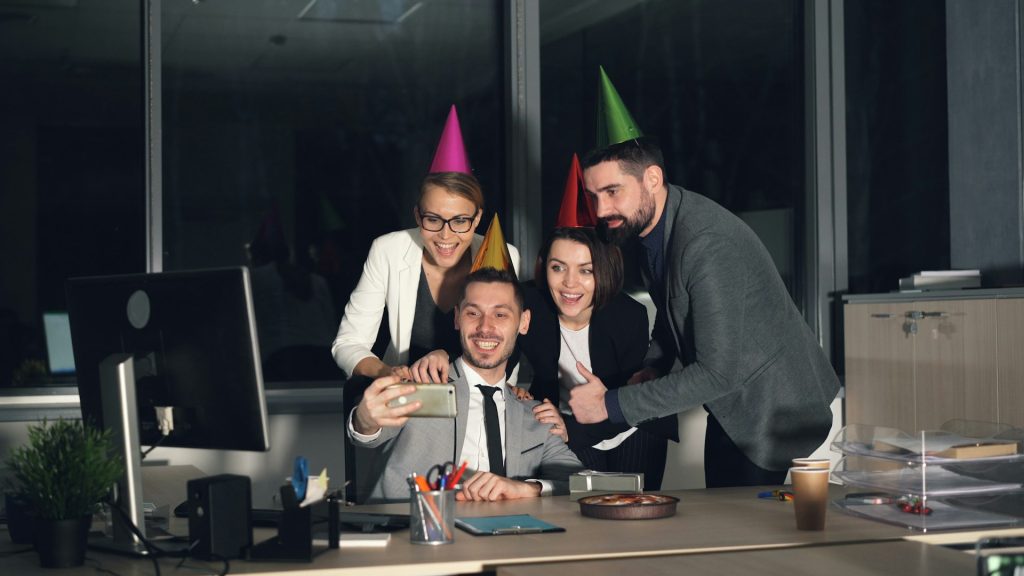 Co-workers taking a selfie at an office party