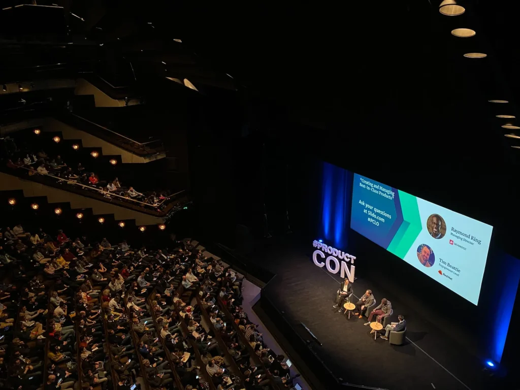Conference audience in front of a stage screen