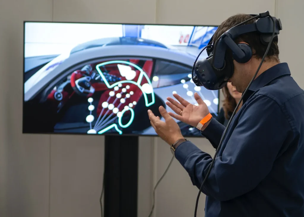 Person using a VR headset in front of a racing game screen